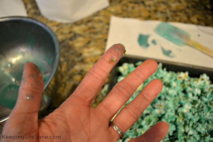 hand that is sticky with blue candied popcorn