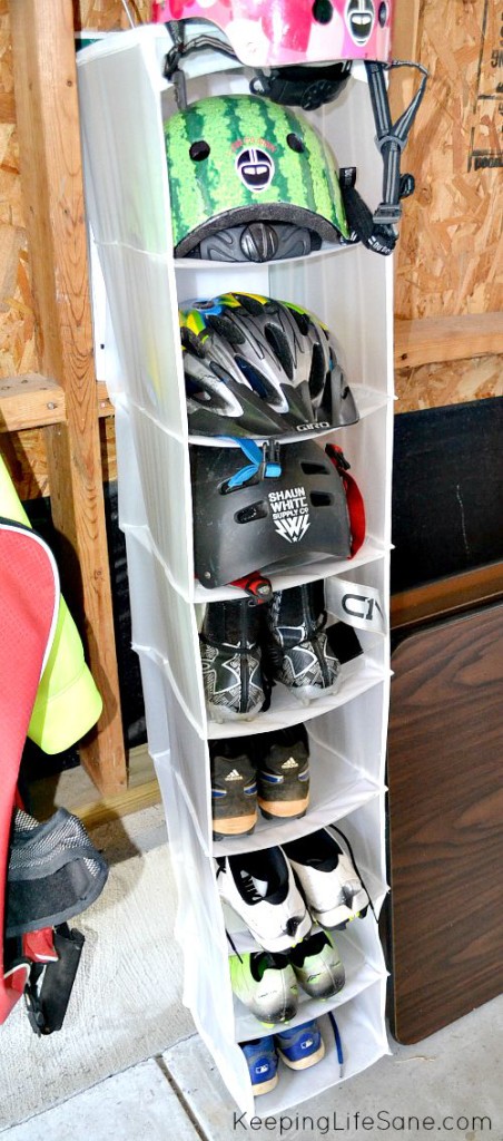 white closet organizer in garage with cleats and bike helmets