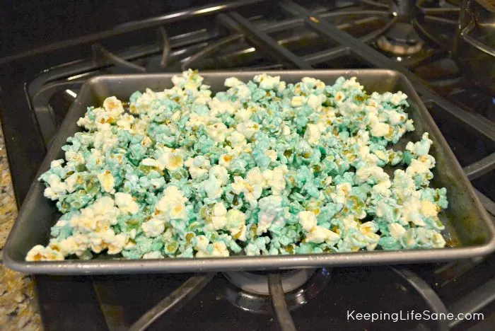 blue candied popcorn on baking sheet sitting on stove