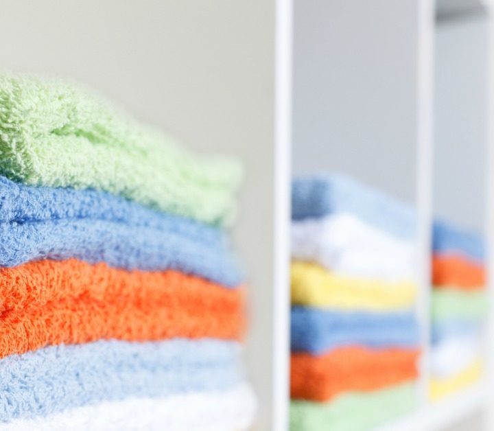 stack of colorful towels in white cabinet