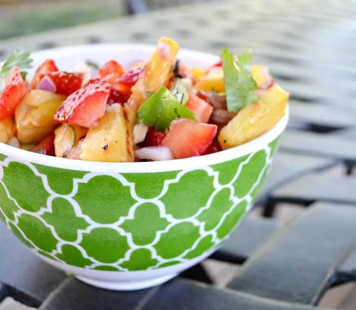 Green bowl with grilled pineapple salad with strawberries with cilantro