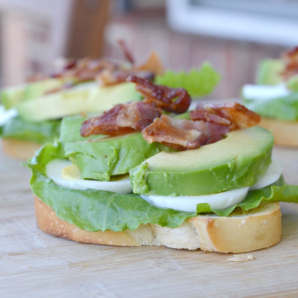 toast with lettuce, hard boil eggs, gree avocados with bacon on top