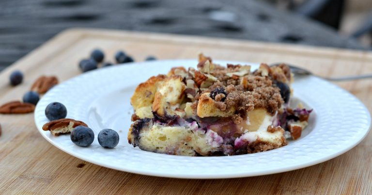 white bowl on cutting board with french toast casserole with blueberries