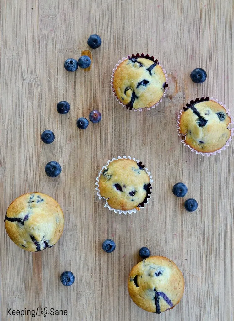 overhead view of eggless blueberry muffin on a wooden cutting board
