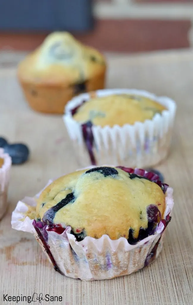closeup view of no egg blueberry muffin on a wooden cutting board
