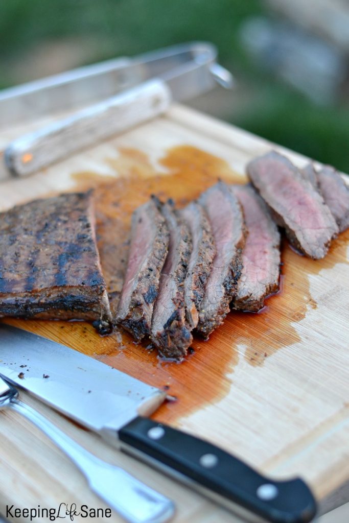 juicy london broil sliced up on a cutting board