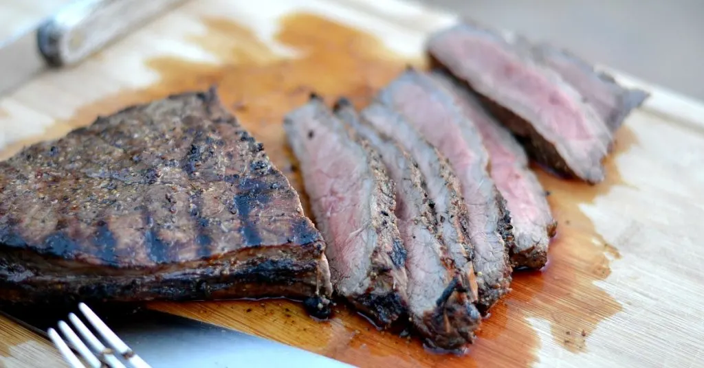 uicy london broil sliced up on a cutting board