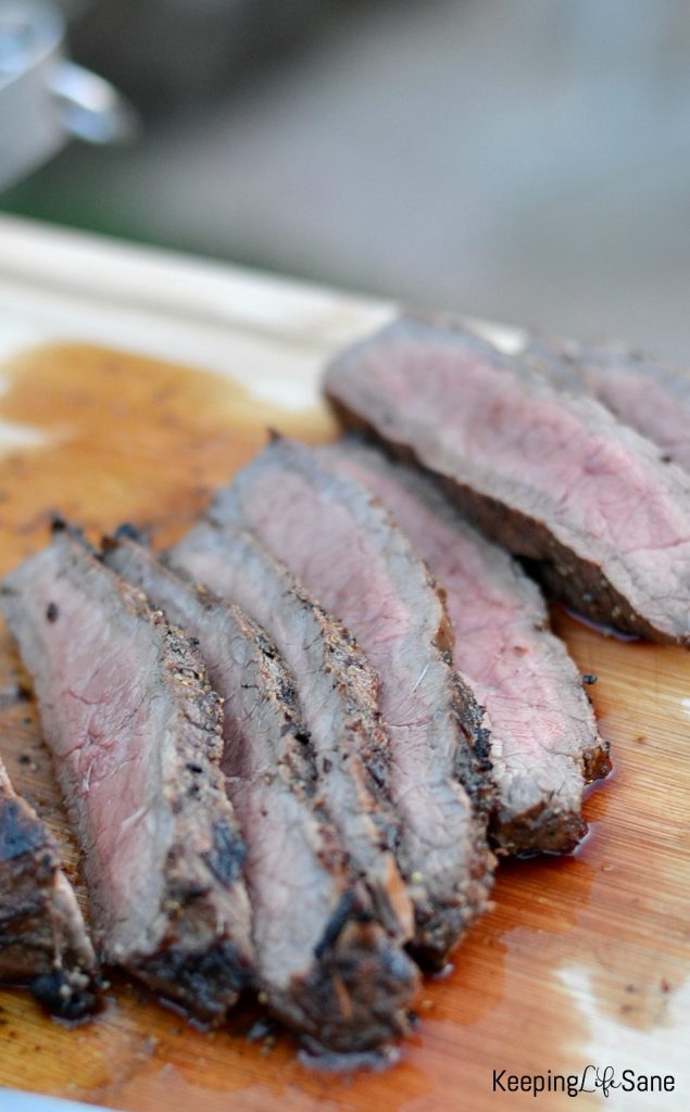 juicy london broil sliced up on a cutting board