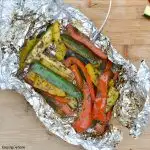 overhead view of zucchini and peppers on foil that have been grilled
