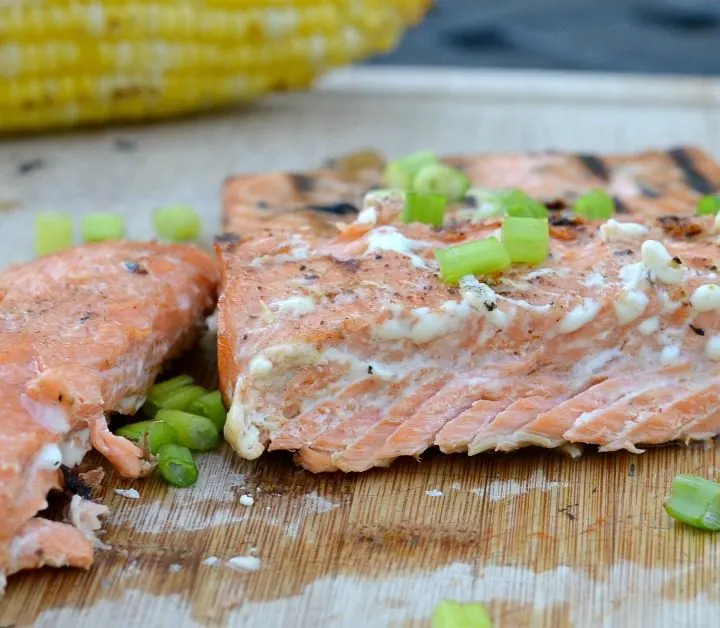 salmon cutting board with green chives on top