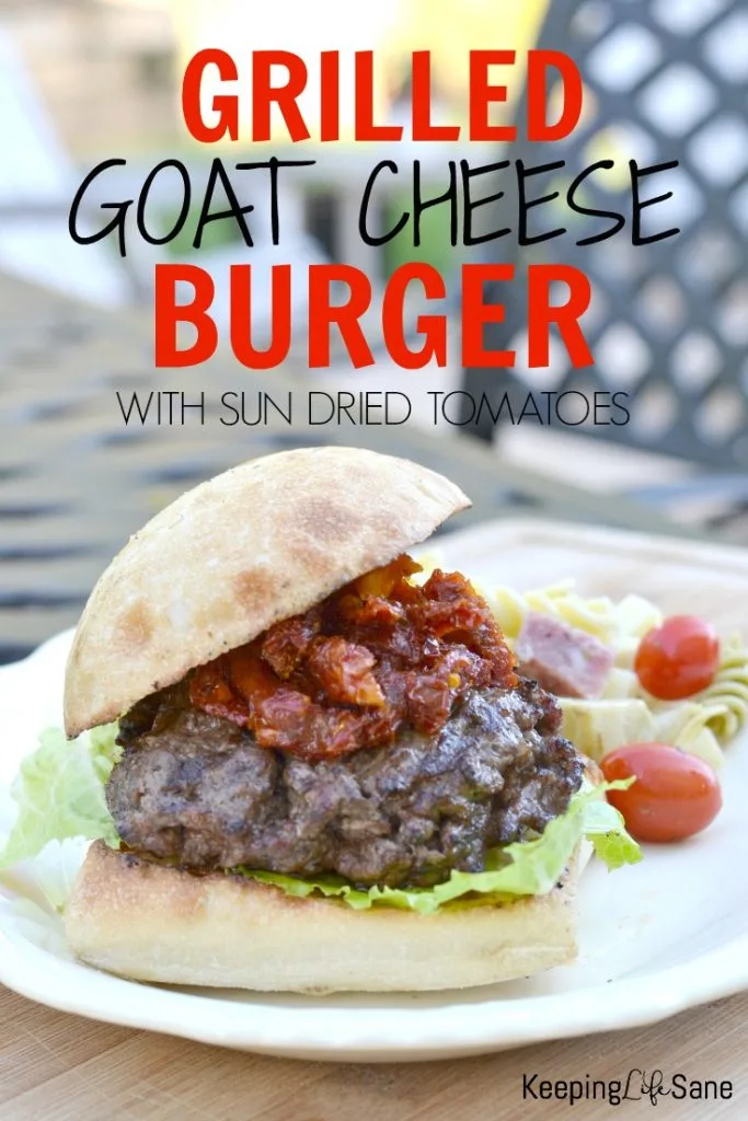 white platter with burger with lettuce and sun dried tomatoes.