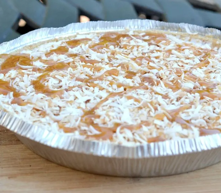 coconut ice cream pie with toasted coconut on top with drizzled caramel
