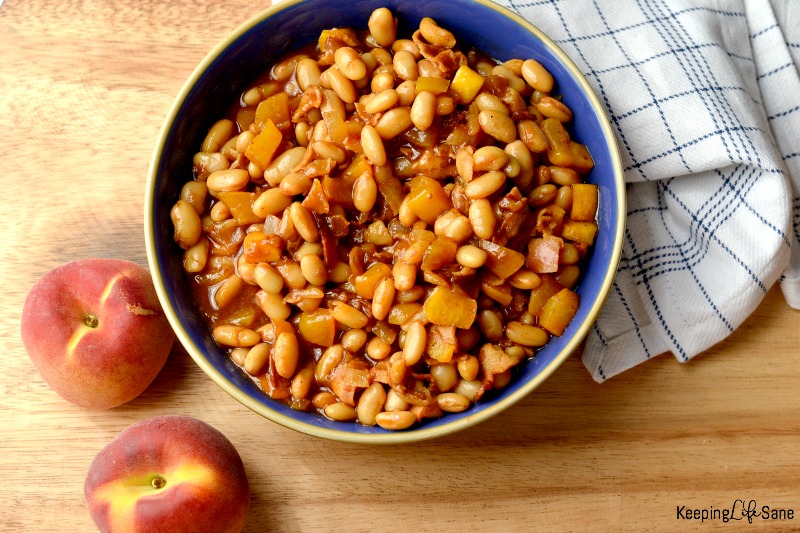 overhead view of peach baked beans in blue bowl on cutting board