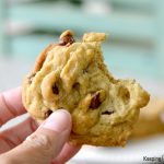 hand holding eggless chocolate chip cookie with bite taken out of it