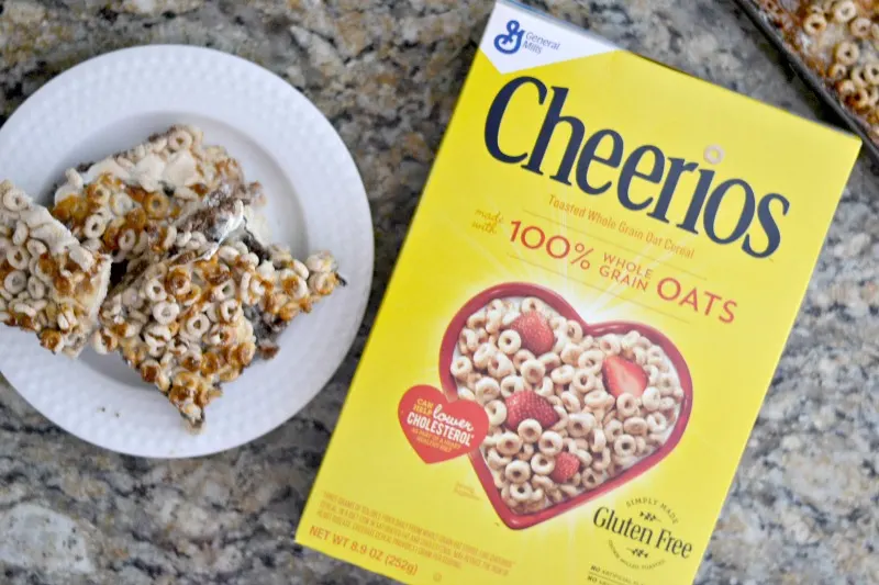 overhead view of Cheerio bars on white plate sitting on kitchen counter with a box of Cheerios laying right beside it