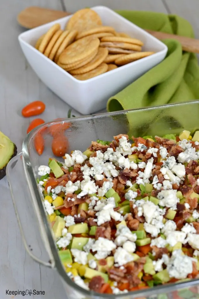 cob dip in a glass dish with white bowl full of crackers