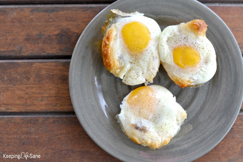 three crecent roll egg cups on grey plate, ready to serve, with slat and pepper sprinkled on them