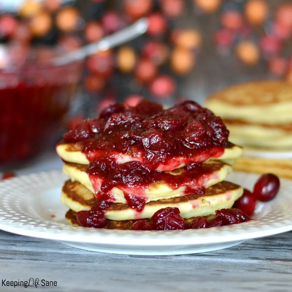 Stack of pancakes with cranberry sauce dripping over them