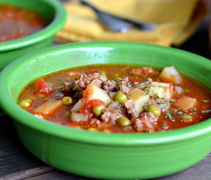 ground beef tomato soup in green bowl on a wooden table