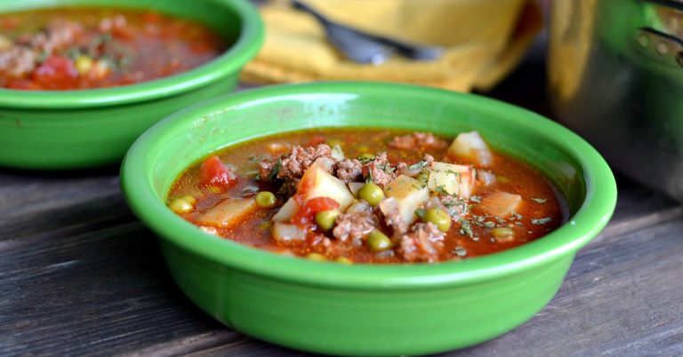 ground beef tomato soup in green bowl on a wooden table