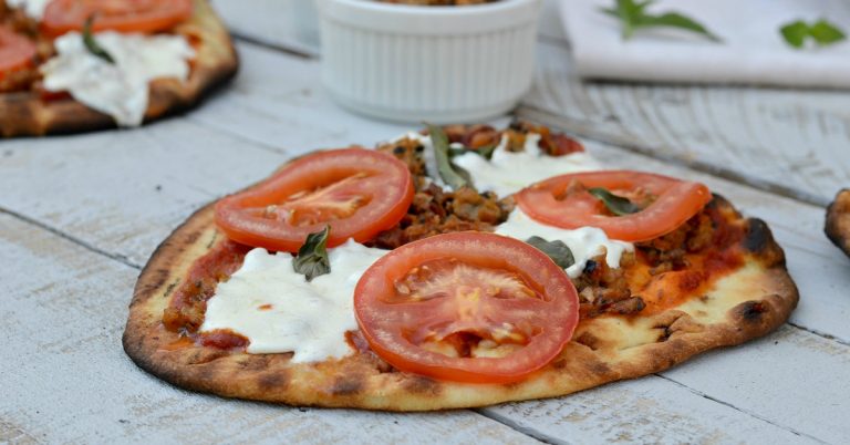ground chicken on pizza with Mozzarella, basil leaves and tomato slices