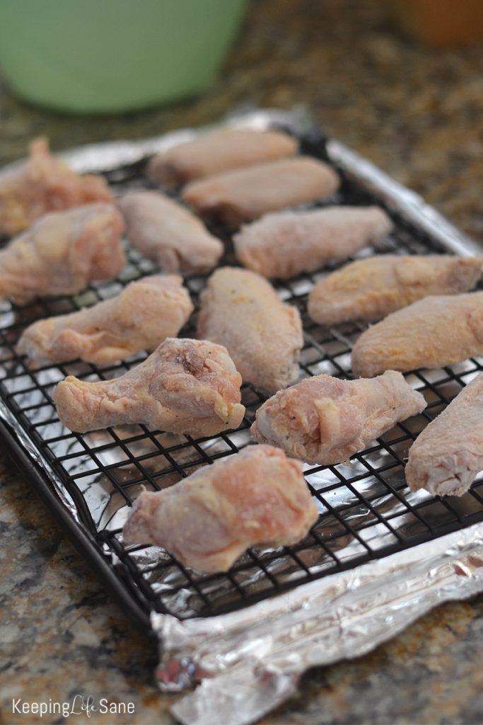 raw chicken wings on wire rack before going in the oven