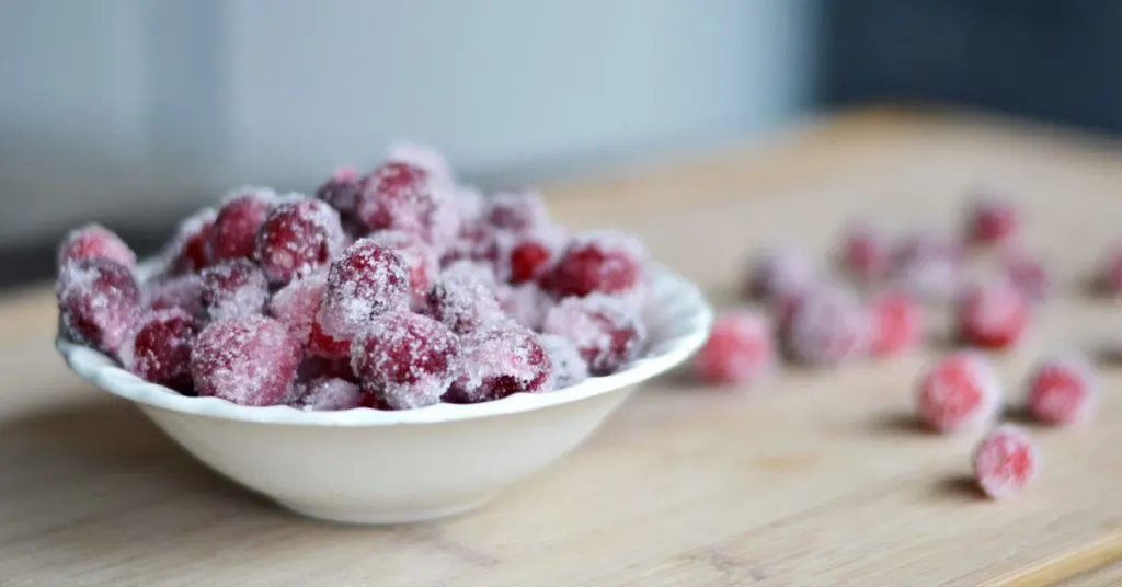 small white bowl with sugared cranberries piled high