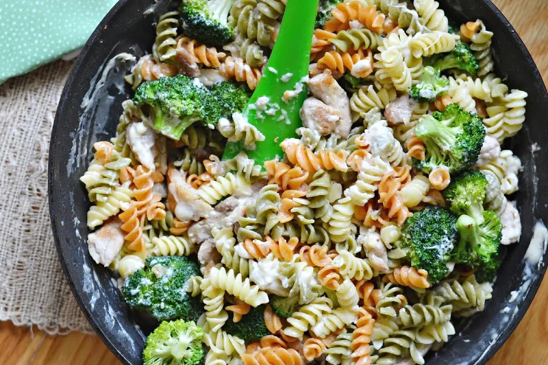 closeup overhead view of skillet with pasta, broccoli and chicken meal
