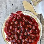 overhead view of cherry cream cheese pie with cherries on top on wooden table