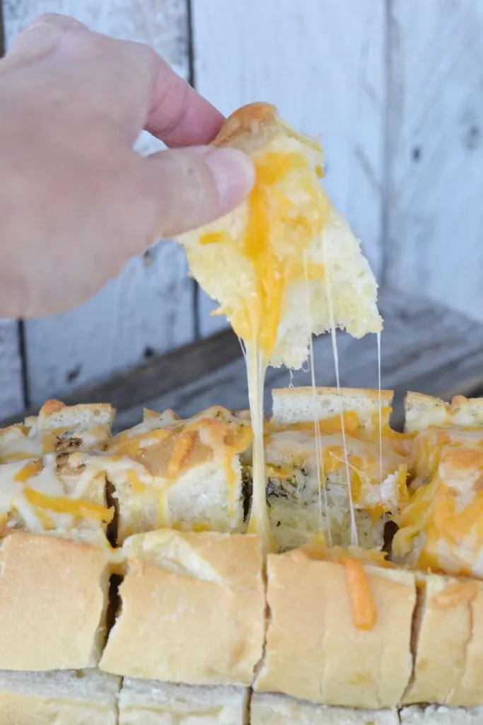 photo of recipe for cheesy bread with melty cheese being pulled apart