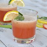 clear glass with strawberry lemonade mimosa with lemon on side of glass with basil leaf
