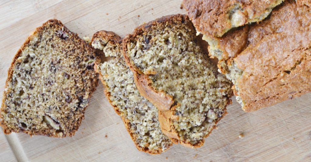 overhead view of banana bread without eggs recipe sliced up on cutting board