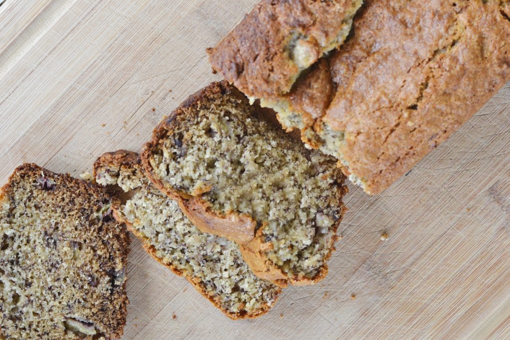 overhead view of banana bread without eggs recipe sliced up on cutting board