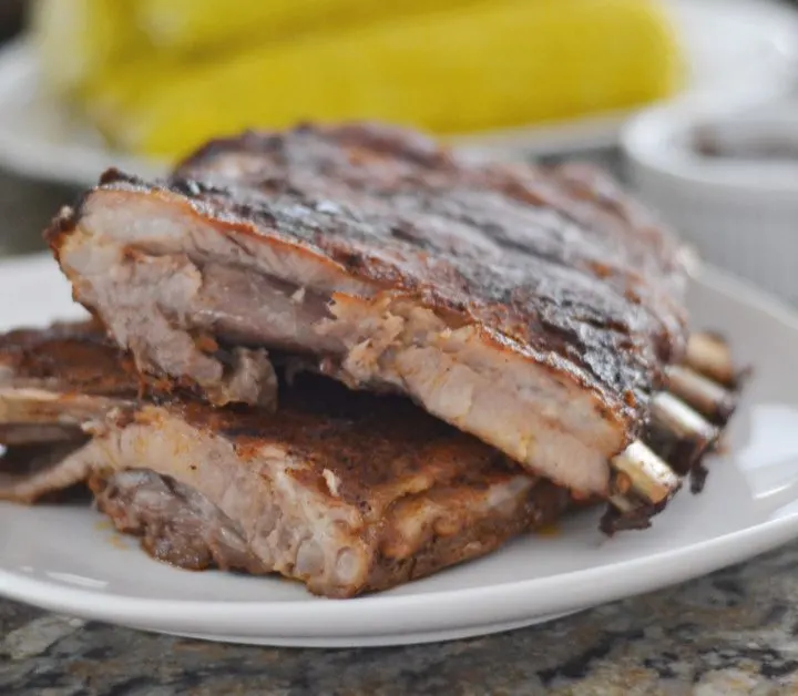 Ribs laying on white platter on kitchen counter