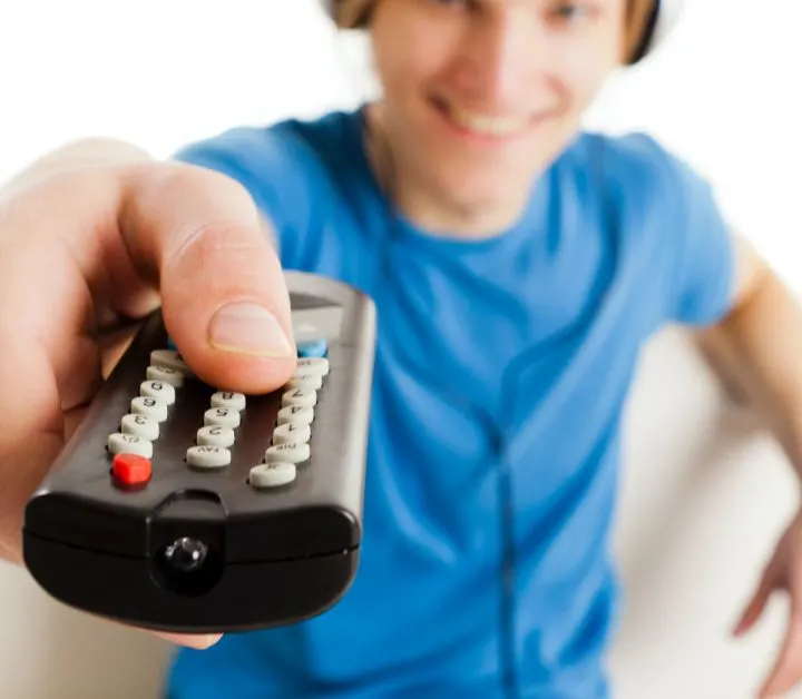 boy in blue shirt holding remote out