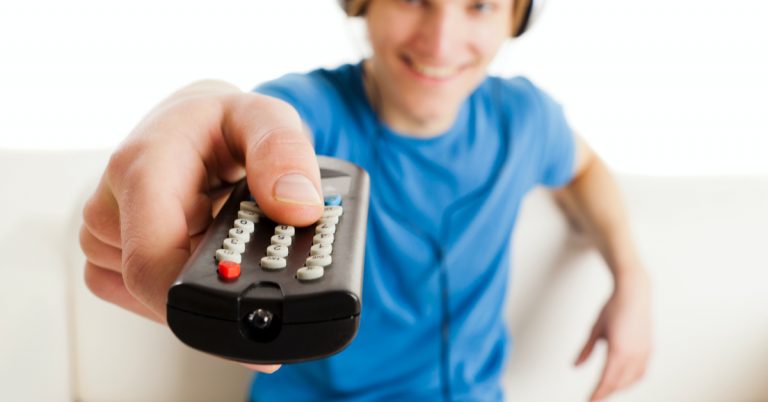 boy in blue shirt holding remote out