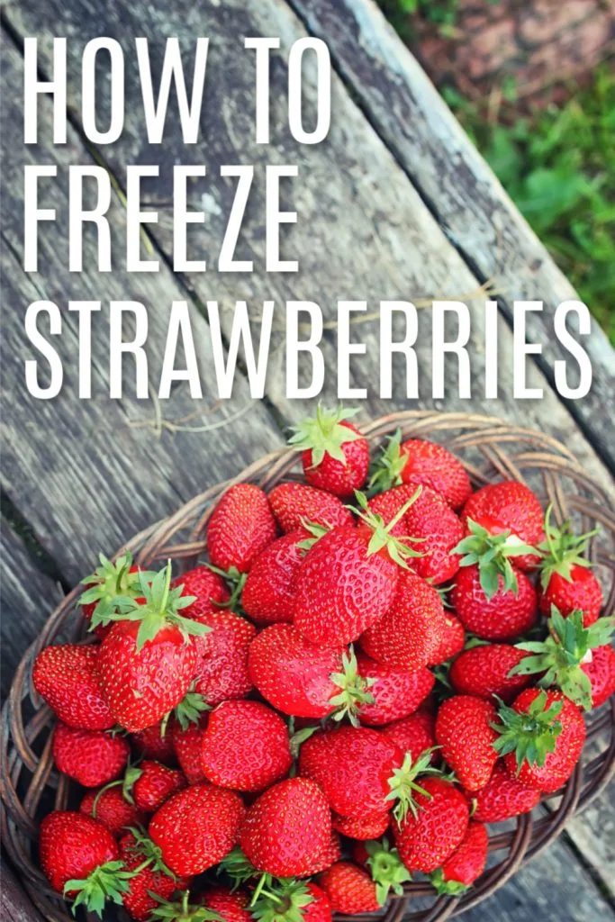 overhead view basket of fresh strawberries sitting outside on a wooden table