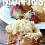 eggless strawberry muffins cracked open in front of a white plate with strawberries with more muffins.