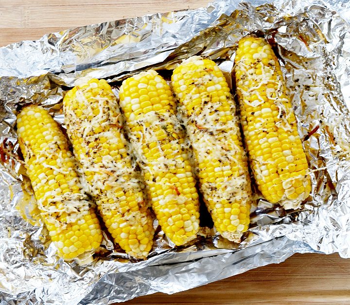 corn on the cob in foil with cheese on top on top of foil