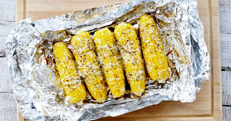 corn on the cob in foil with cheese on top on top of foil