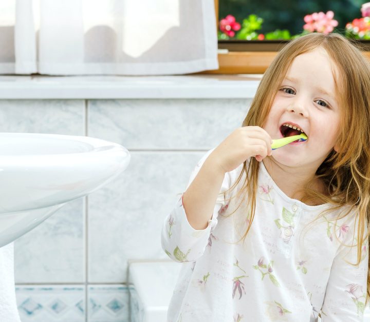 Little girl cleaning the teeth in bathroom, morning