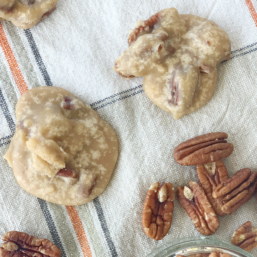 overhead view of two pecan pralines with some pecans scattered about