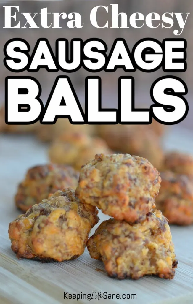 Cooked sausage balls with cheese piled up on a cutting board