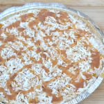 top of coconut ice cream pie with toasted coconut and caramel drizzled on top