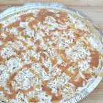 top of coconut ice cream pie with toasted coconut and caramel drizzled on top