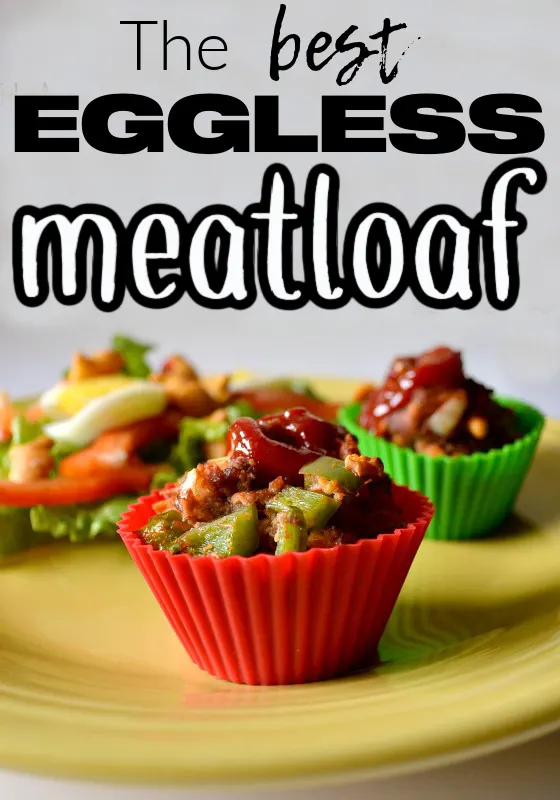 yellow plate with red and green silicone liners with cooked meatloaf inside with a squirt of ketchup on top.