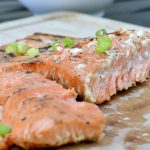 closeup of grilled salmon with chives on top