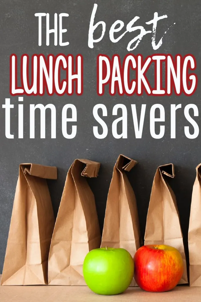 lunch bags lined against black chalkboard with one red apple and one green apple