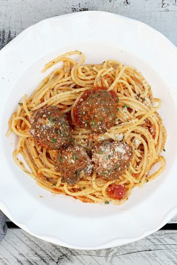 overhead shot of white bowl with with spaghetti and meatballs