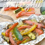 Colorful sliced bell peppers and zucchini in foil sprinkled with herbs